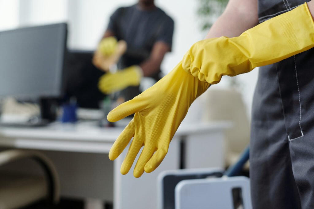 Hands of female worker of contemporary cleaning company putting on gloves